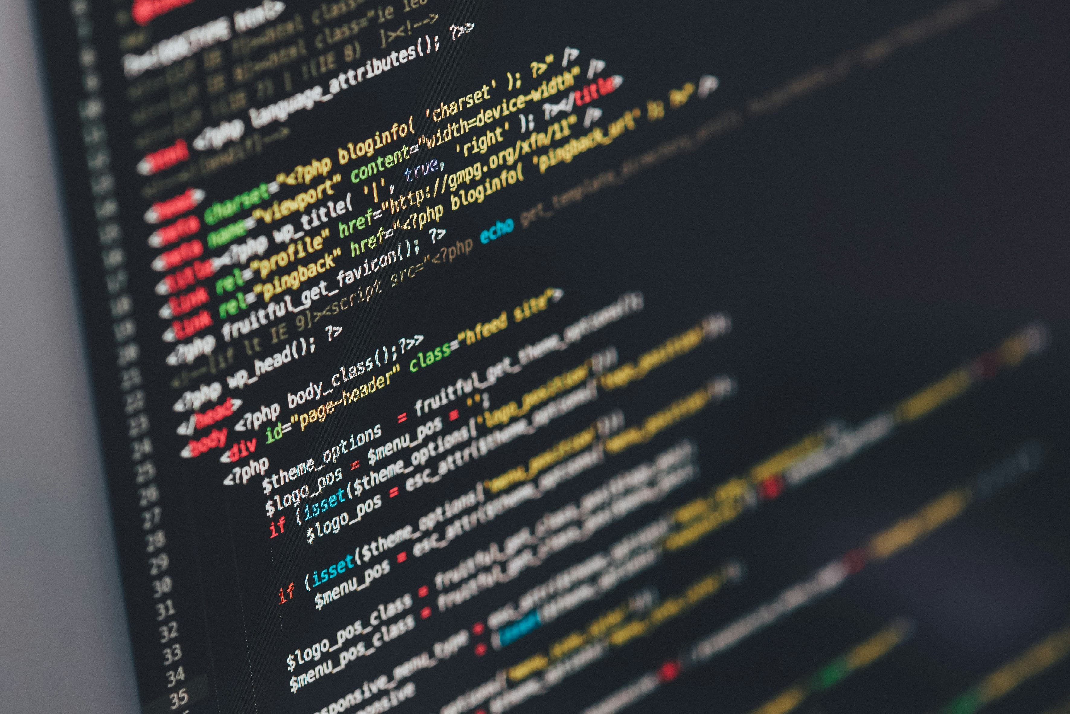 Developer writing code on a dark monitor — engineering shaped around the business brief